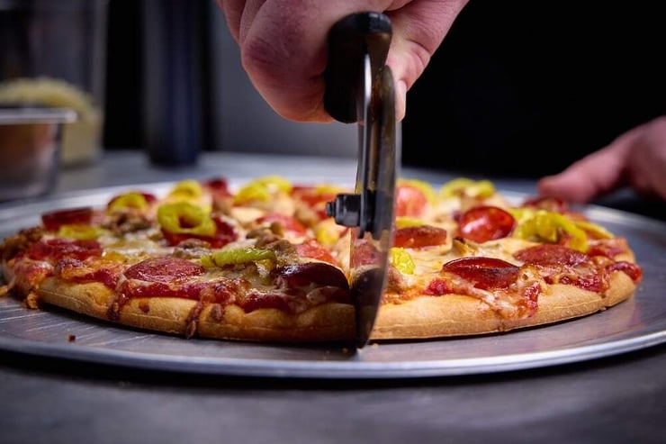 hand tossed pizza being sliced