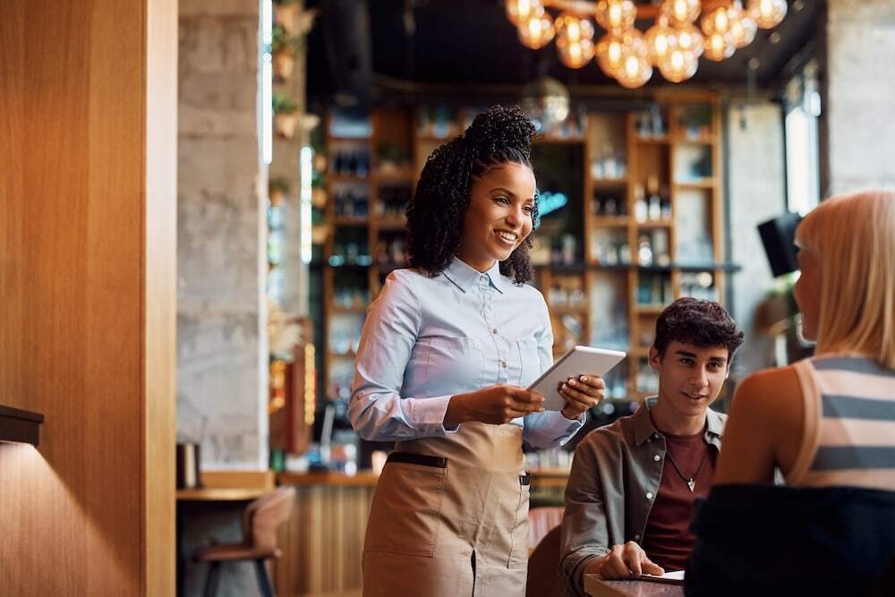 waitress taking order of guests at pizzeria