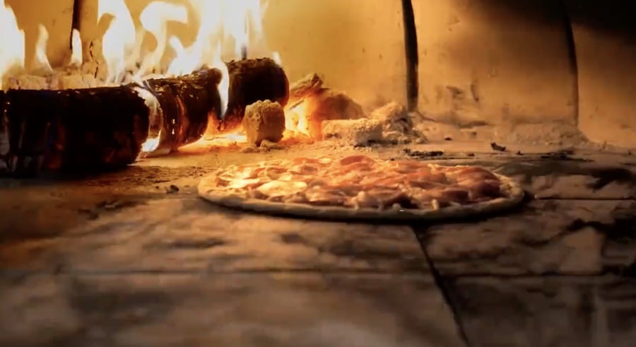 position pizza close to flame in wood fired oven